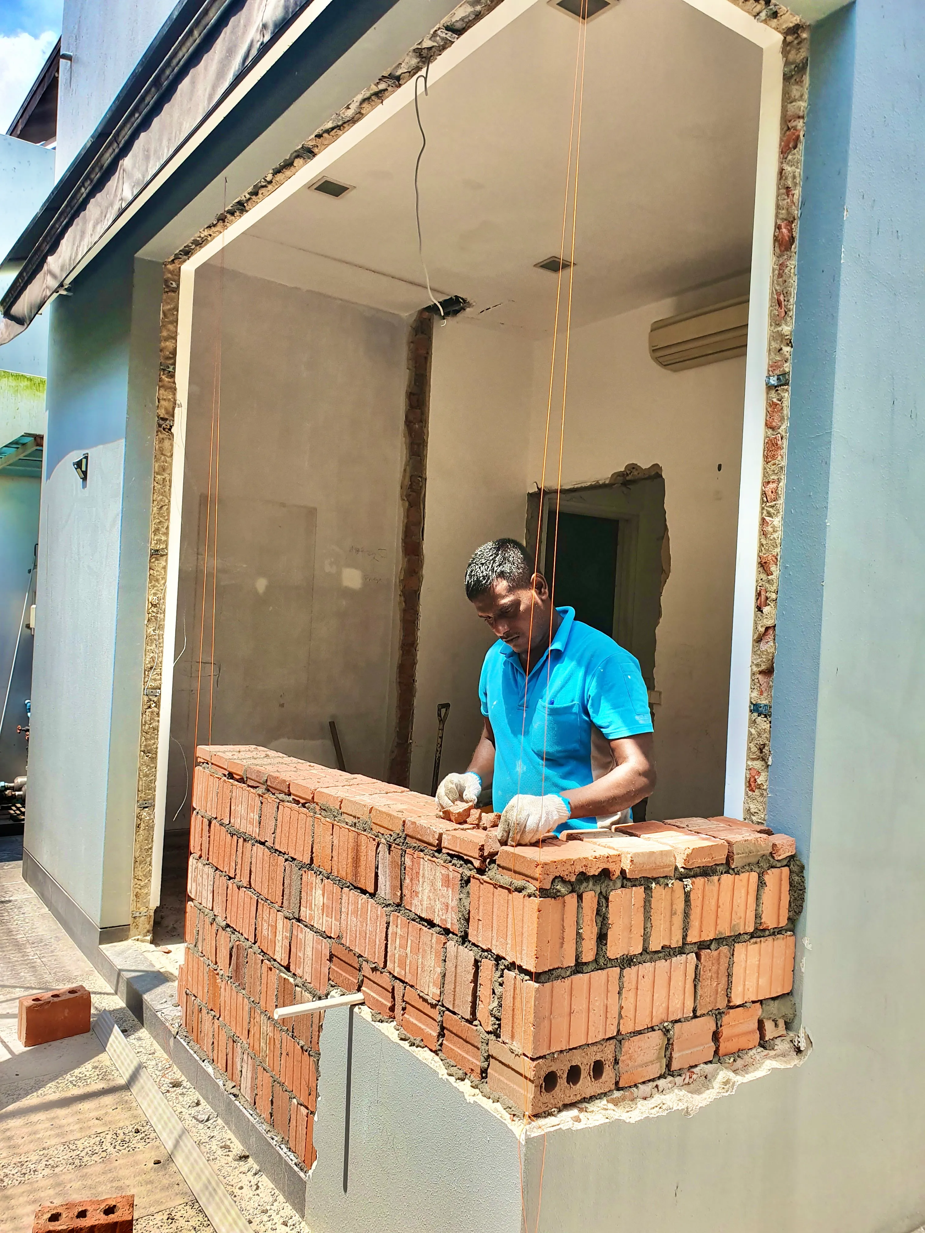 Worker laying a brick wall during a home renovation project